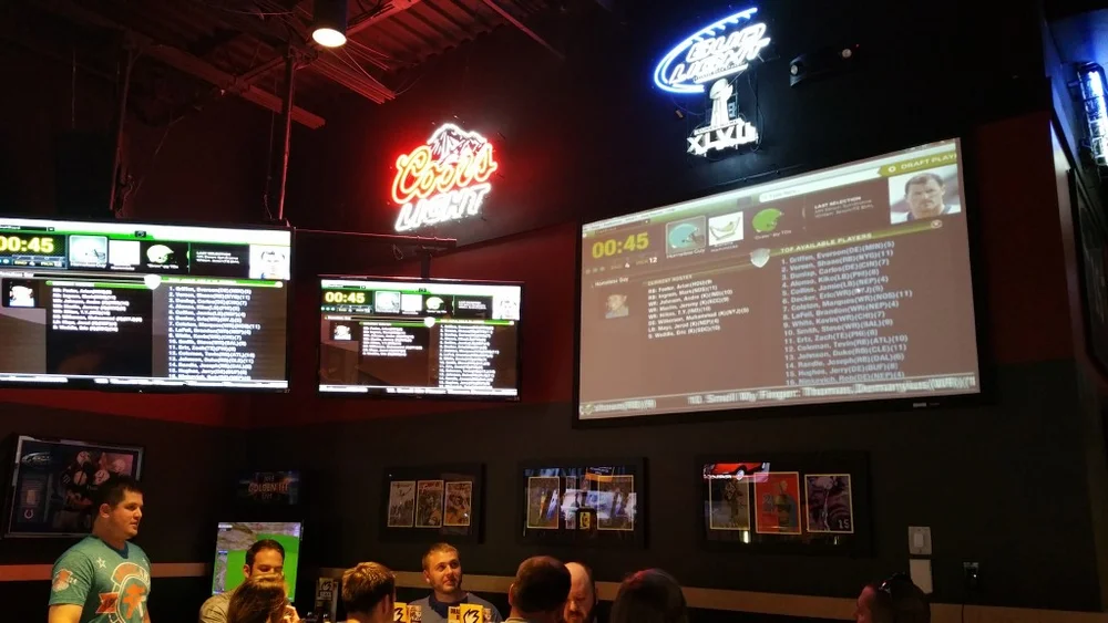 A FanDraft live fantasy football draft board on a TV